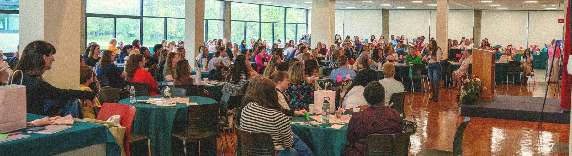 Katy Ursta speaking to a packed room of women at a leadership event